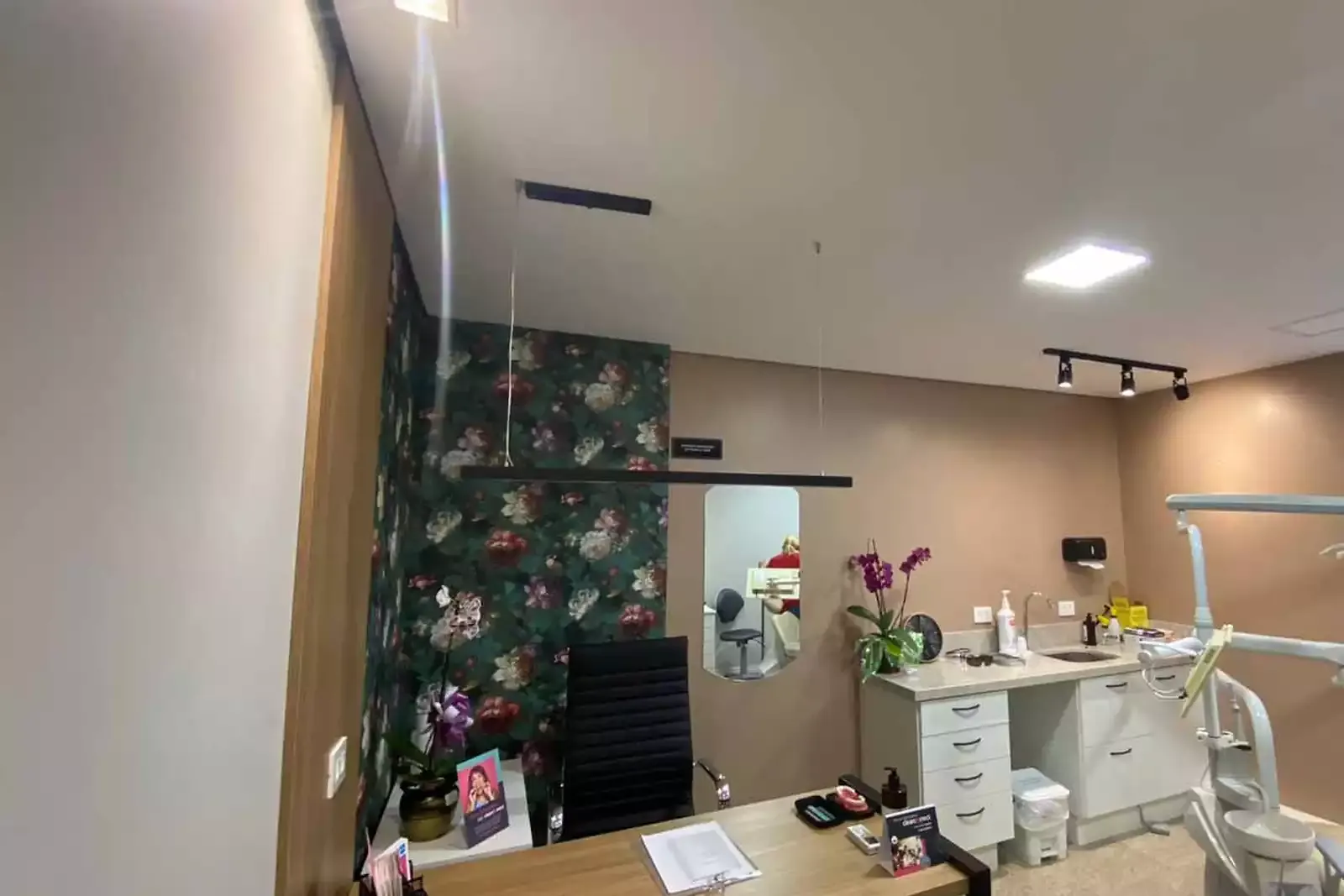 Consultório com papel de parede floral e orquídeas